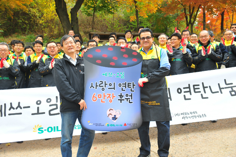 S-OIL 오스만 알 감디 CE(앞줄 오른쪽)가 홍제동 개미마을에서 사랑의 연탄나눔운동본부 이동섭 상임이사에게 저소득가정과 독거노인들을 위한 연탄 6만장을 전달하고 있다.