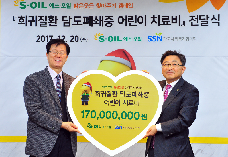 S-OIL 이창재 부사장(오른쪽)이 한국사회복지협의회 서신일 부회장에게 담도폐쇄증 환아를 돕기 위한 임직원 급여우수리 모금액을 전달한 뒤 기념촬영을 하고 있다.